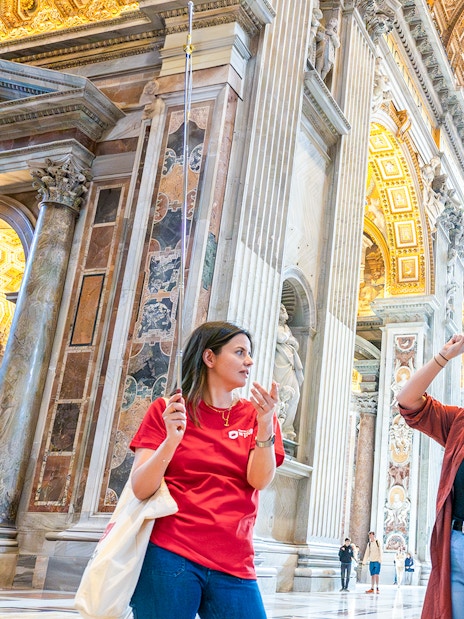 Tour guide explaining St. Peter’s Basilica interior to visitors.