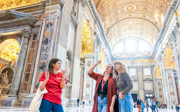 Tour guide explaining St. Peter’s Basilica interior to visitors.