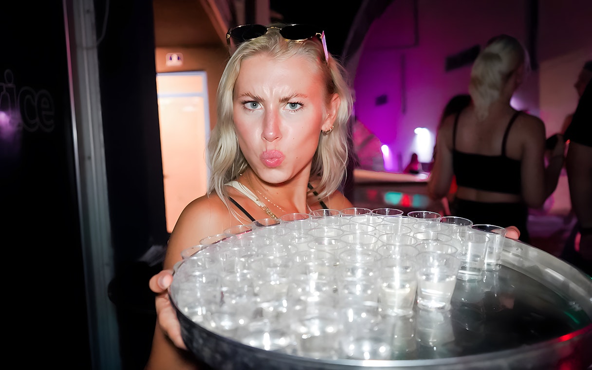 Person holding a tray of shot glasses during a boat crawl in Split.