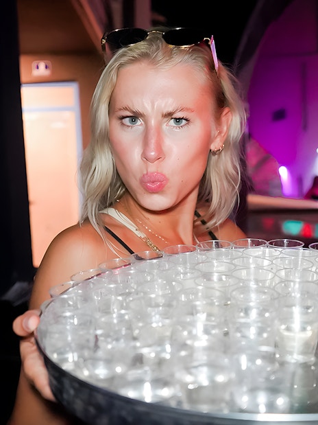 Person holding a tray of shot glasses during a boat crawl in Split.