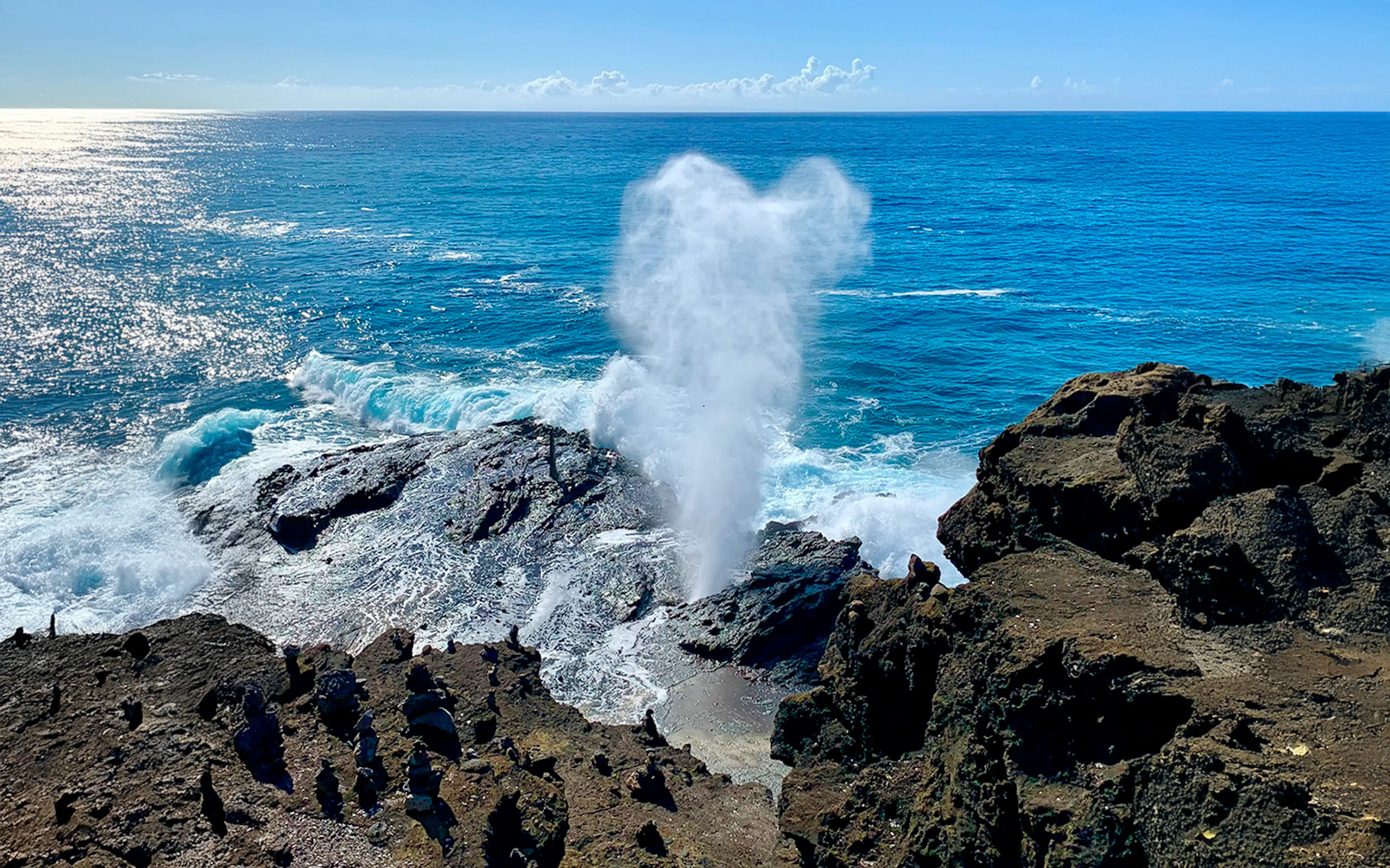 Halona Blowhole spouting water against rocky coastline, Oahu, Hawaii.