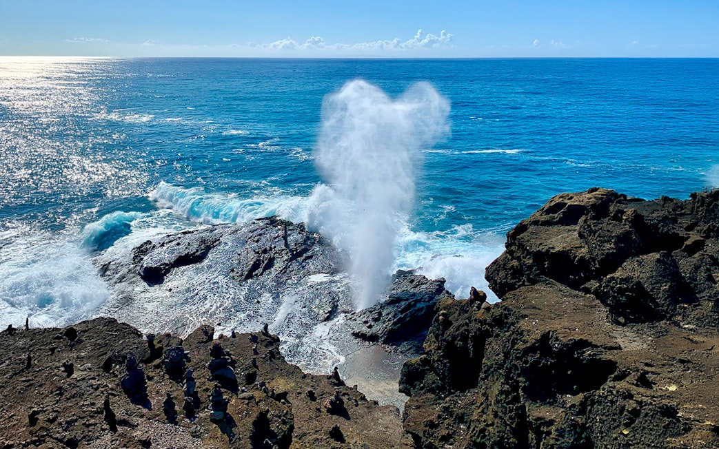 Halona Blowhole spouting water against rocky coastline, Oahu, Hawaii.