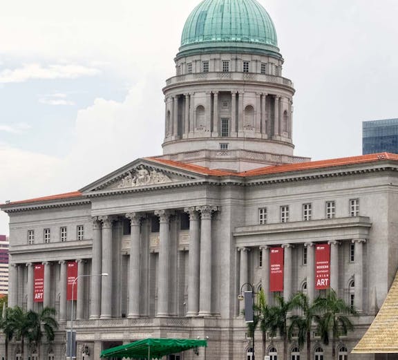 National Gallery Singapore with dome and columns, banners for modern art exhibition.