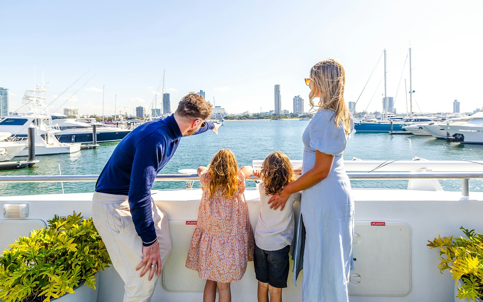 Family on top deck enjoying view of Marina Mirage yachts during Gold Coast buffet lunch.