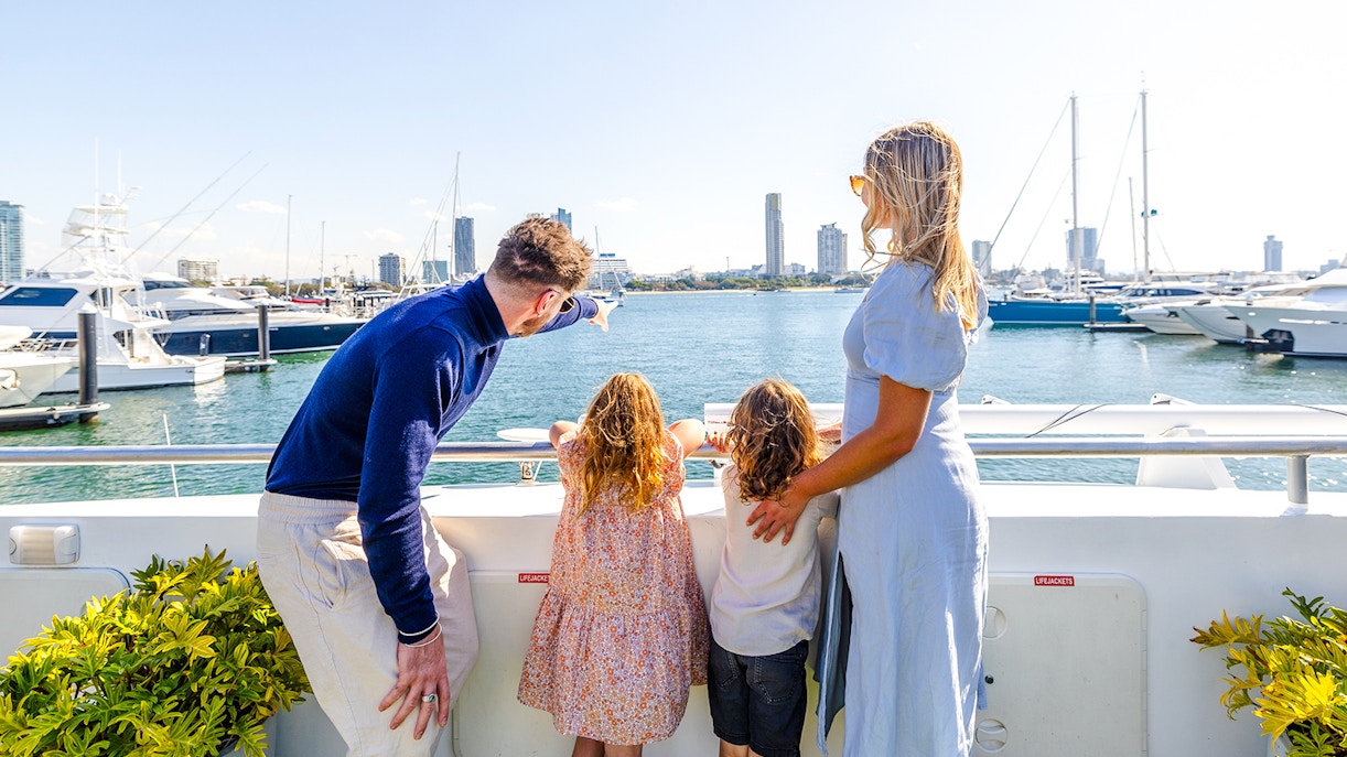 Family on top deck enjoying view of Marina Mirage yachts during Gold Coast buffet lunch.