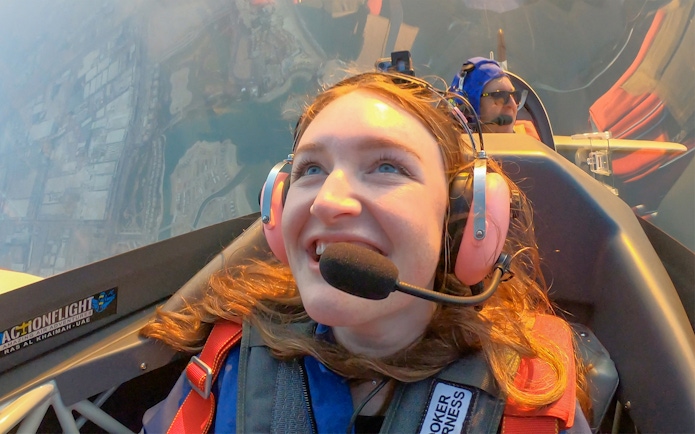 Woman enjoying GFORCE Aerobatic Passenger Experience in flight.