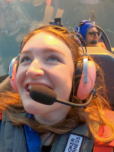 Woman enjoying GFORCE Aerobatic Passenger Experience in flight.