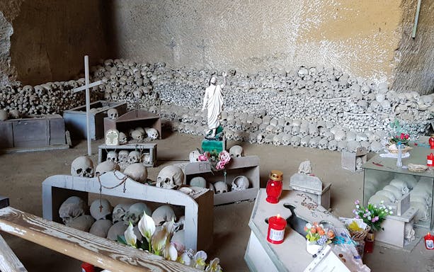 Skulls and religious artifacts at Fontanelle Cemetery, Naples, on the Rione Sanità walking tour.