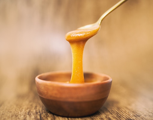 Beekeeper harvesting honey from a hive in New Zealand, showcasing Manuka honey production process.