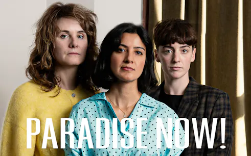 Three people standing together with the text "Paradise Now!" in front.