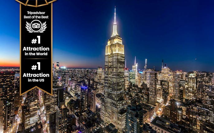 Empire State Building illuminated at night in New York City skyline.