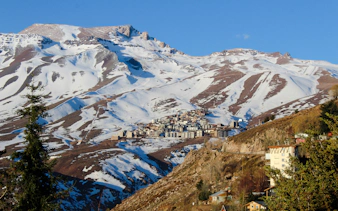 Snow-covered Andes Mountains near Santiago with a village nestled in the valley.