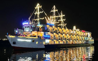 Cruise ship Indochina Queen illuminated at night on Saigon River.