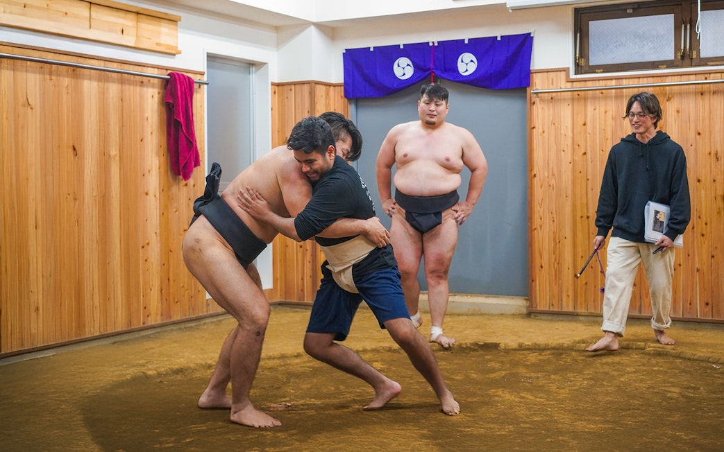 Sumo wrestlers practicing in a Tokyo dojo during a sumo wrestling experience.
