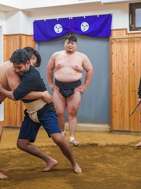 Sumo wrestlers practicing in a Tokyo dojo during a sumo wrestling experience.