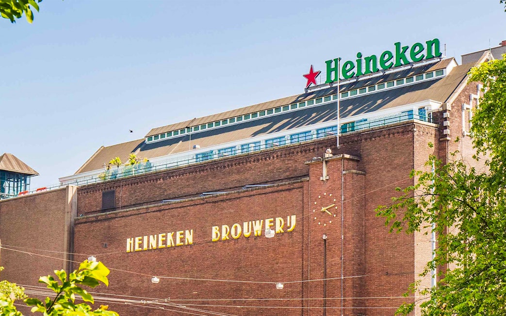 Heineken Brewery building in Amsterdam with signage and clock.