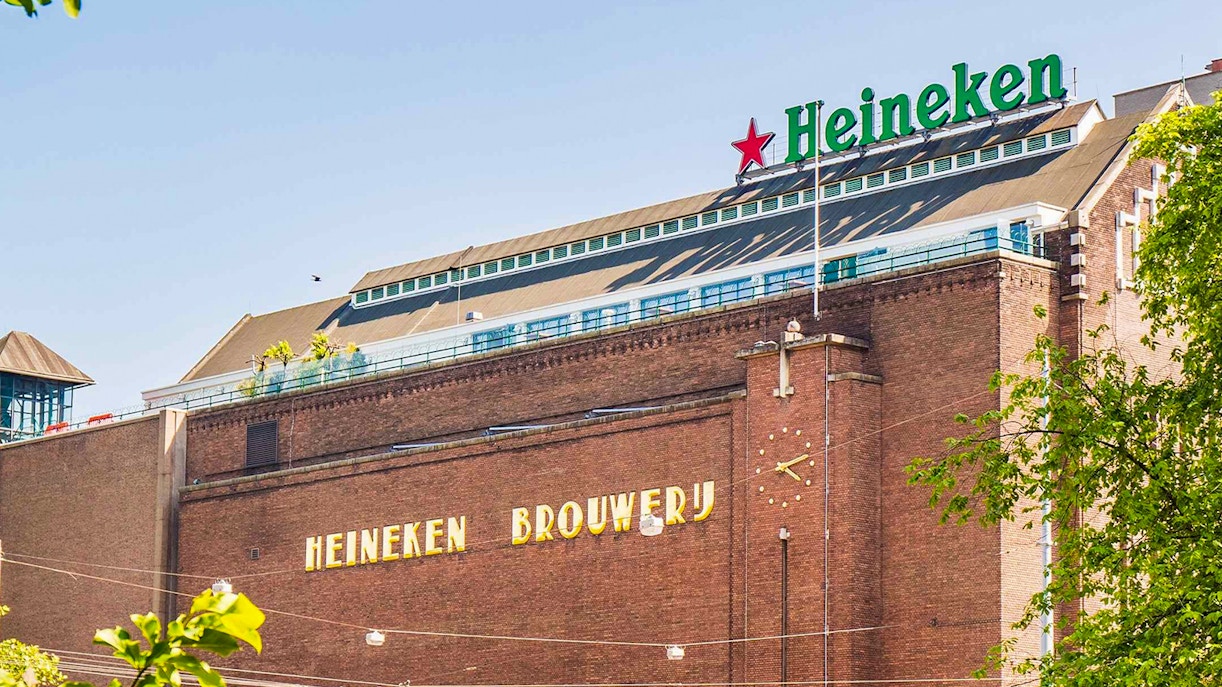 Heineken Brewery building in Amsterdam with signage and clock.