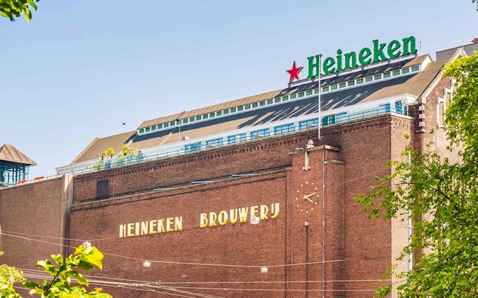 Heineken Brewery building in Amsterdam with signage and clock.