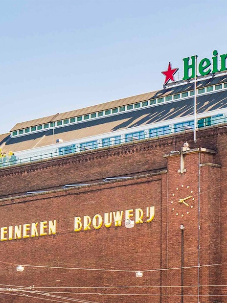 Heineken Brewery building in Amsterdam with signage and clock.