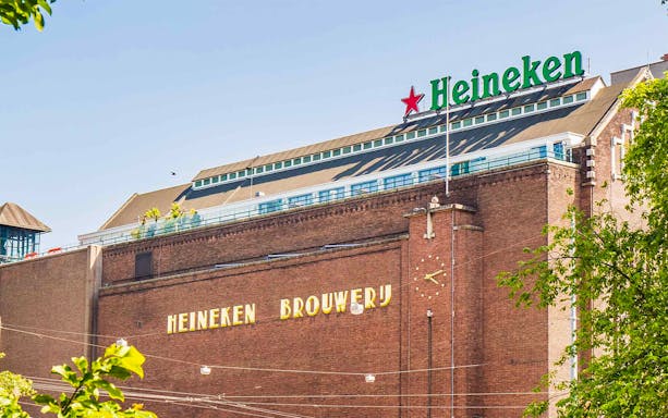 Heineken Brewery building in Amsterdam with signage and clock.