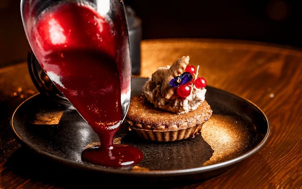 Festive dessert with red sauce and berries at The Great Christmas Feast.