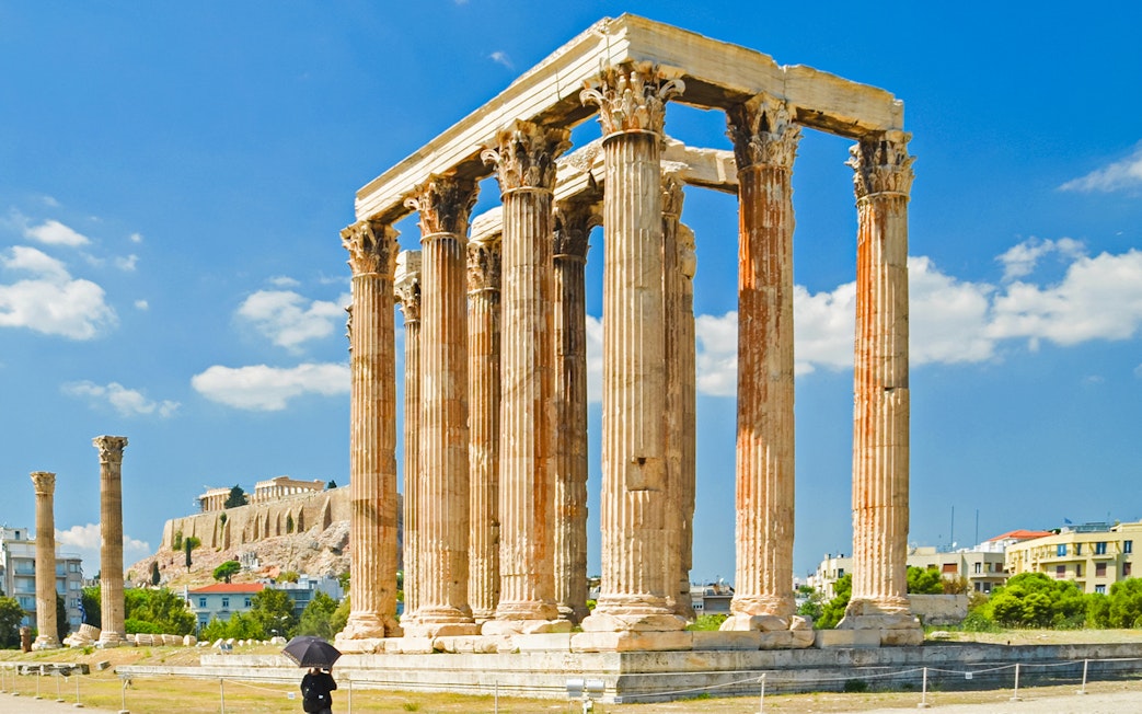 Temple of Olympian Zeus ruins in Athens with Acropolis in the background.