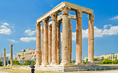 Temple of Olympian Zeus ruins in Athens with Acropolis in the background.