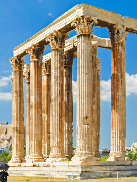 Temple of Olympian Zeus ruins in Athens with Acropolis in the background.