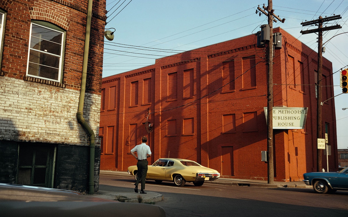 Red brick building with a sign for Methodist Publishing House, viewed from a street corner.