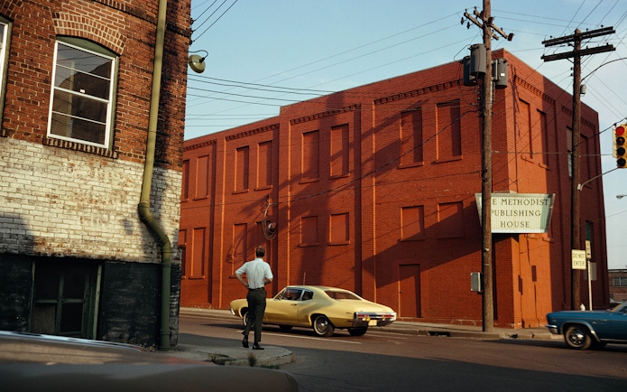 Red brick building with a sign for Methodist Publishing House, viewed from a street corner.