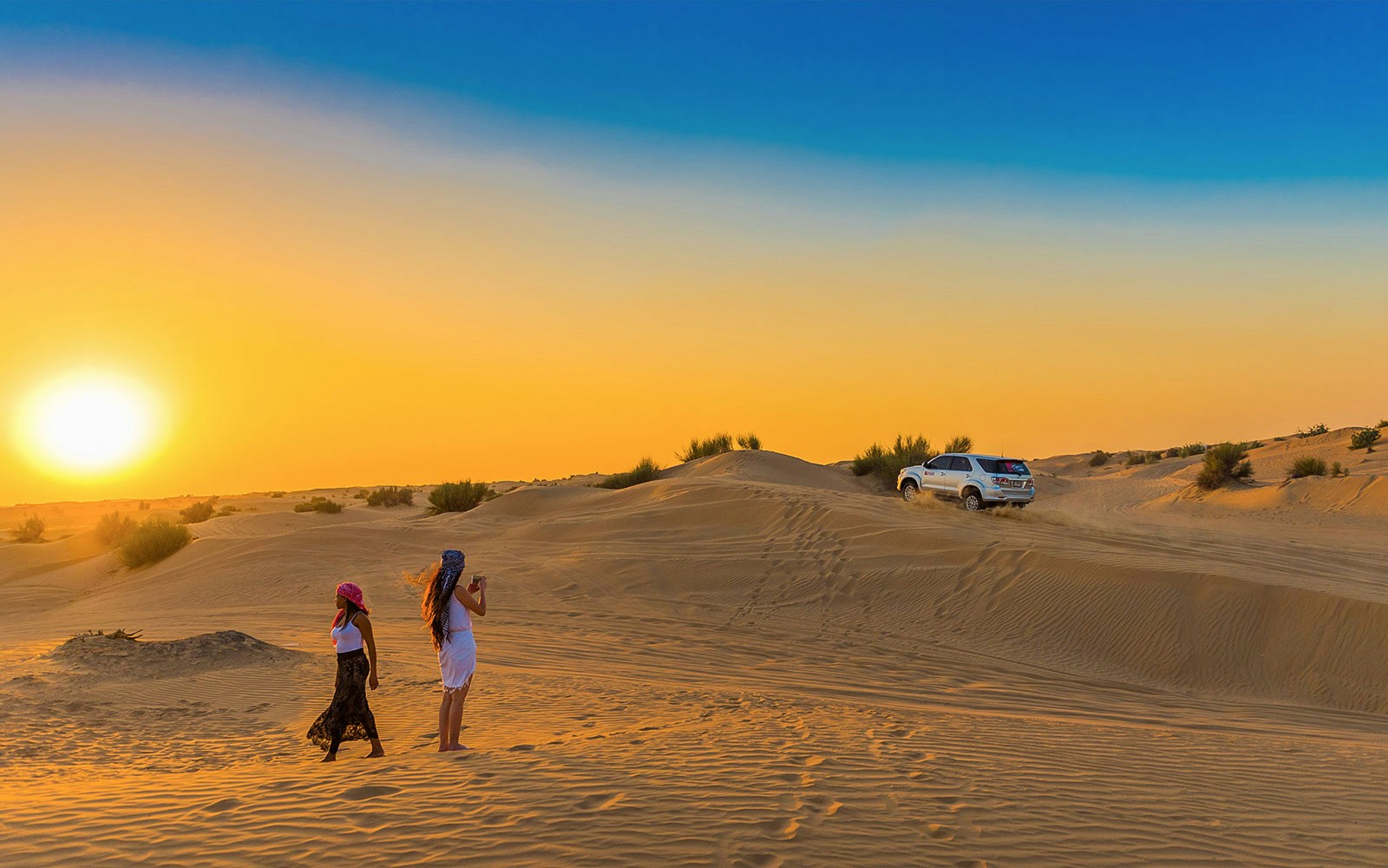 Desert safari with dune bashing and sandboarding in Dubai at sunset.