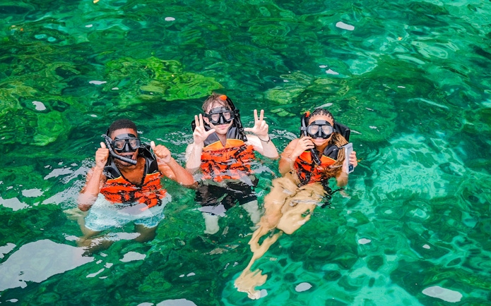 Snorkelers in clear waters of Bamboo Islands, Thailand.