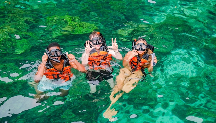 Snorkelers in clear waters of Bamboo Islands, Thailand.