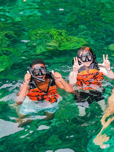 Snorkelers in clear waters of Bamboo Islands, Thailand.
