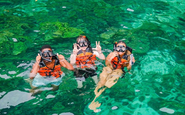 Snorkelers in clear waters of Bamboo Islands, Thailand.