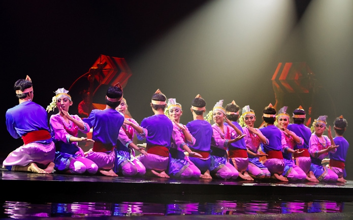 Performers in traditional attire on stage during the Devdan Show in Bali.