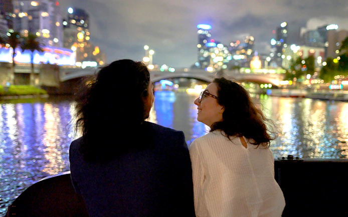 Couple enjoying Melbourne city lights on a dinner cruise.