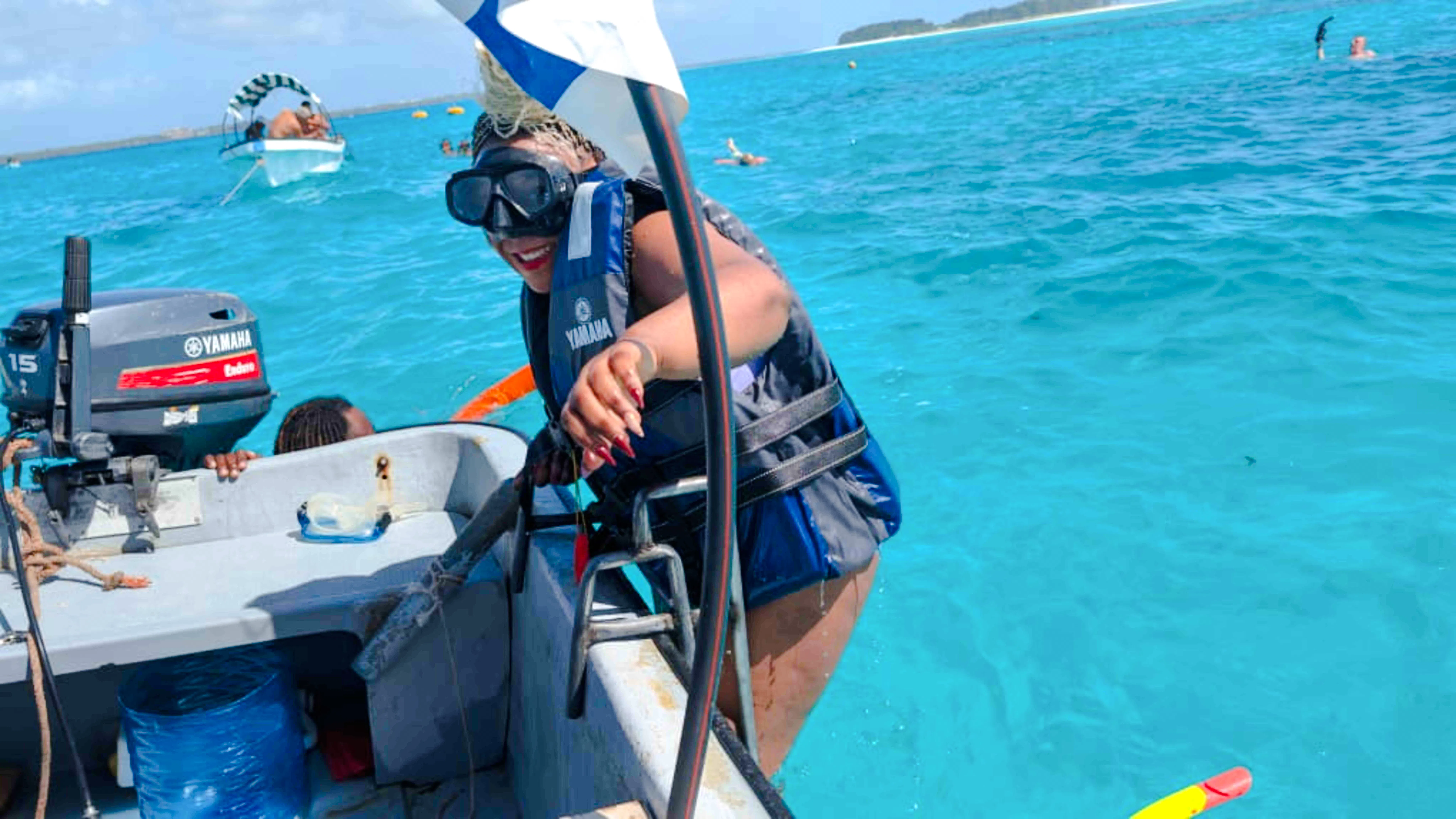 Person climbing onto a boat after snorkeling in Mnemba, Zanzibar.