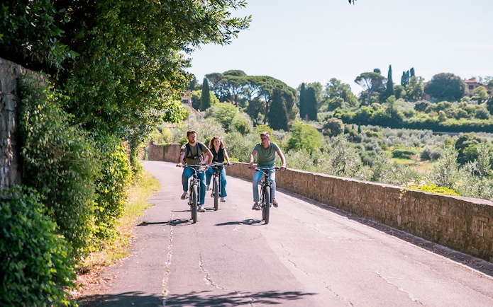 Three people riding electric bikes through Florence hills.