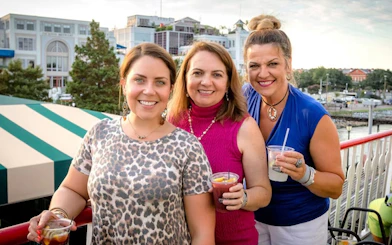 Group enjoying drinks on the deck of a riverboat during a sightseeing jazz cruise in New Orleans.