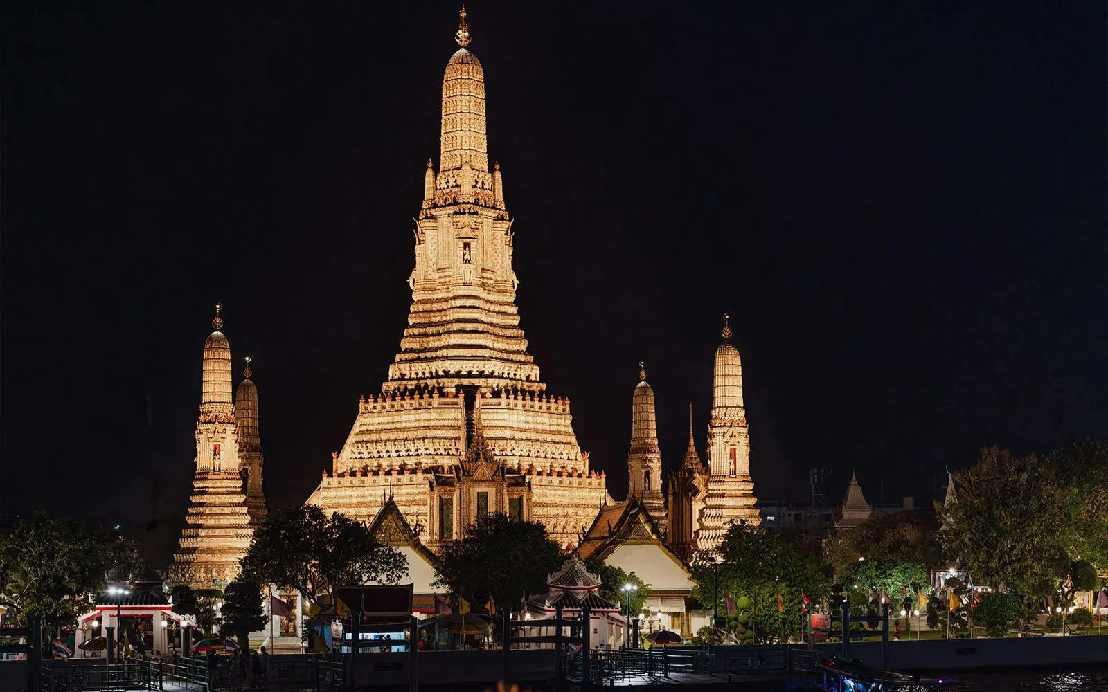 Wat Arun temple illuminated at night, viewed from the Okura Cruise in Bangkok.