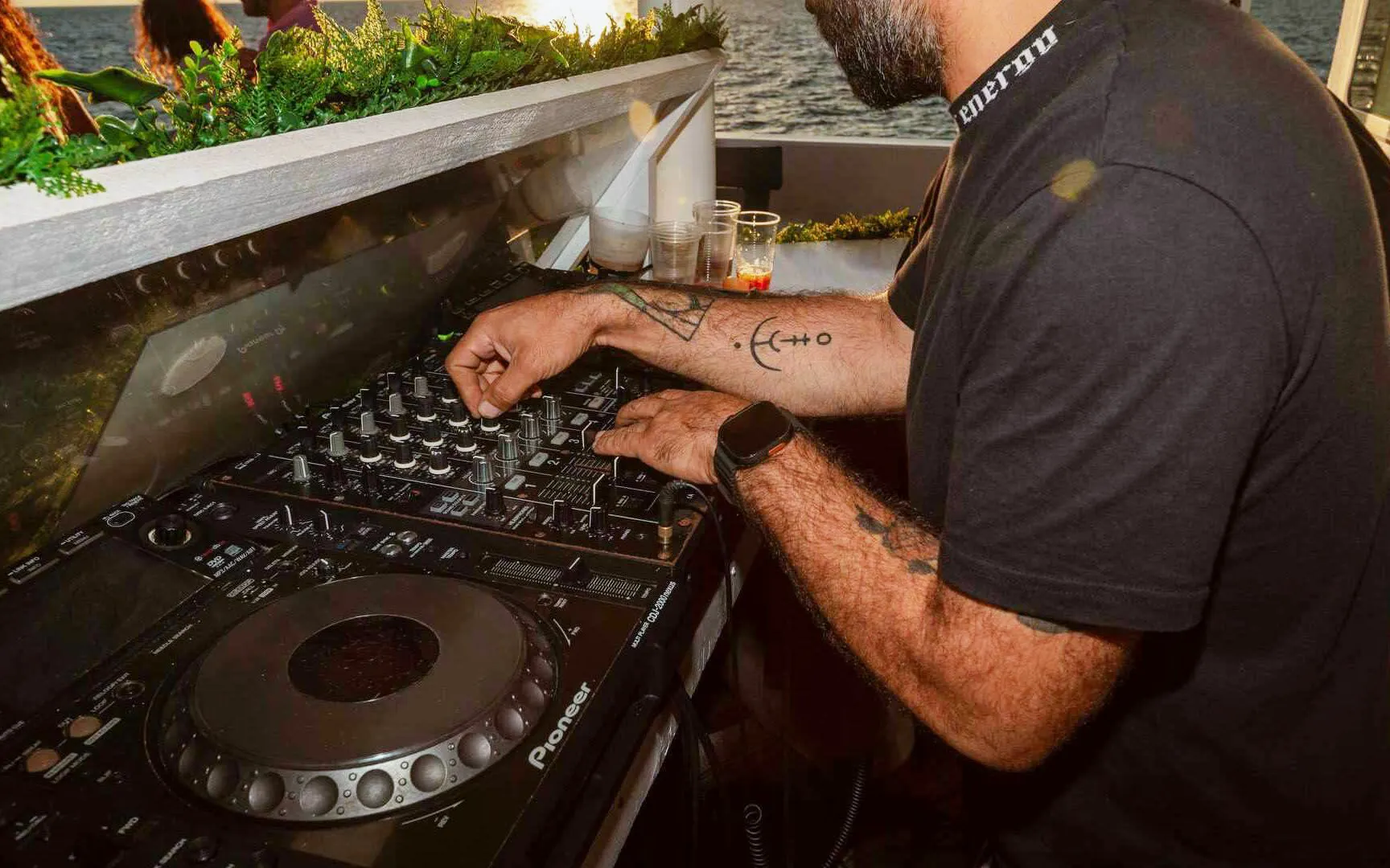 DJ mixing music on deck during Ibiza to Formentera cruise.