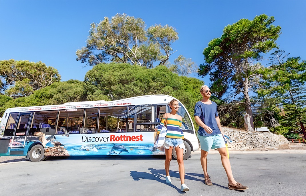 Eine Gruppe von Touristen genießt die Rottnest Island Guided Bus Tour mit einer Fähre von Perth oder Fremantle zurück, mit einem malerischen Blick auf die Küstenlinie der Insel im Hintergrund