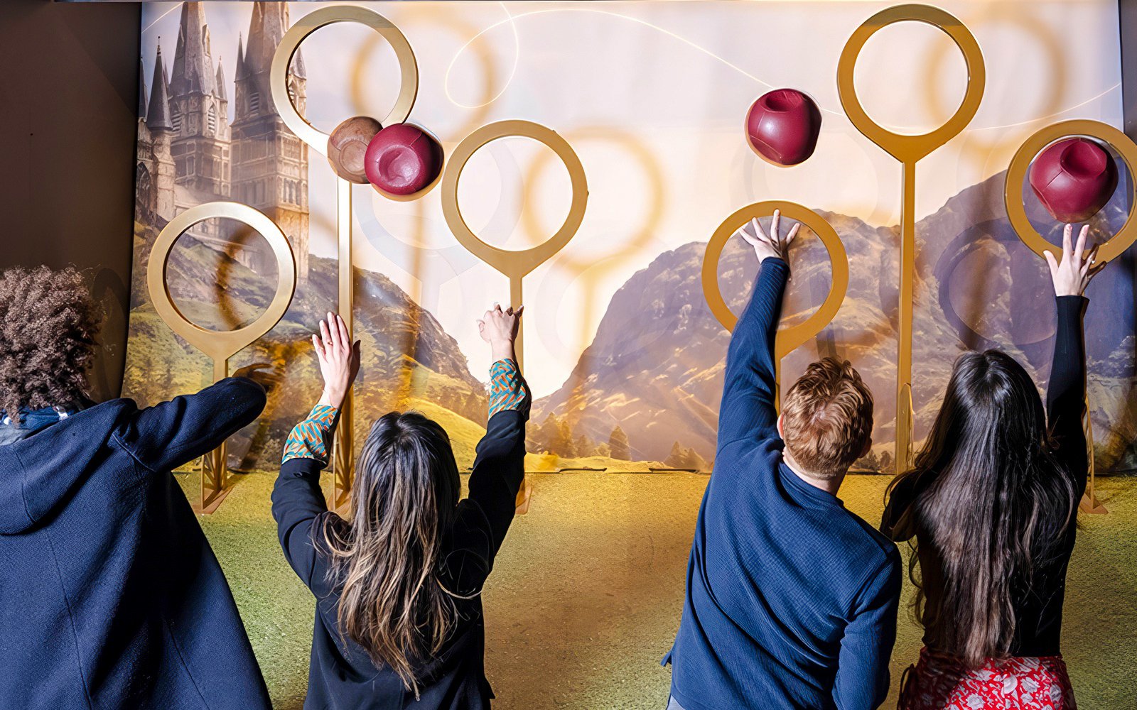 Friends reaching for Quidditch hoops at Harry Potter set tour.