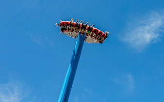 Visitors on a high-thrill ride at Vialand Theme Park, Istanbul against a clear blue sky.