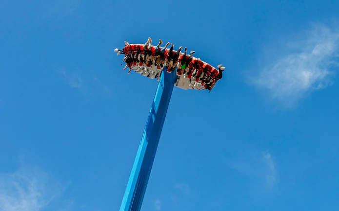 Visitors on a high-thrill ride at Vialand Theme Park, Istanbul against a clear blue sky.