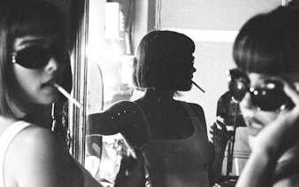 Person in sunglasses with a cigarette, reflected in a mirror, Brisbane nightlife.