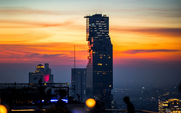 Aerial view of Mahanakhon SkyWalk at sunset in Bangkok.