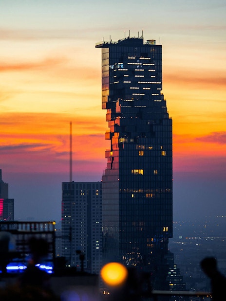 Aerial view of Mahanakhon SkyWalk at sunset in Bangkok.