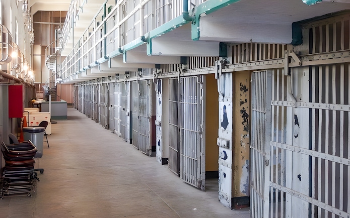 Prison cells on Alcatraz Island, San Francisco, with open barred doors and a walkway.